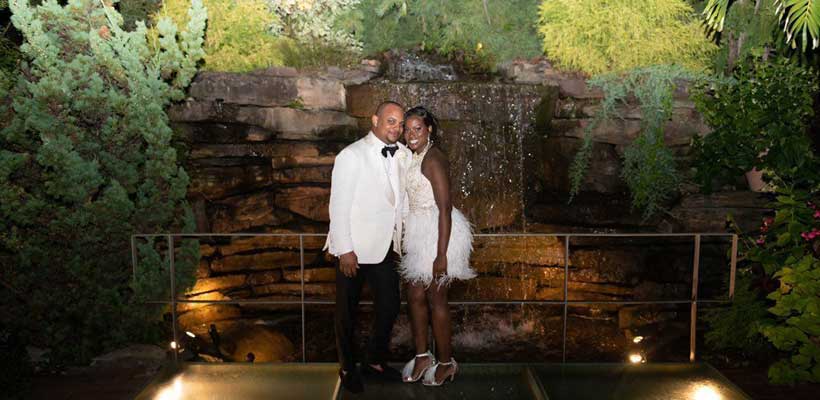 Bride and Groom standing in front of a wall water fountain at Crestwood.
