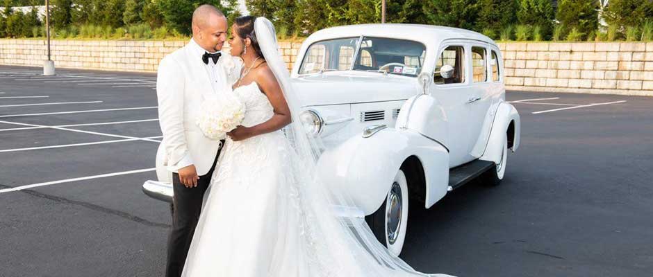 Bride and Groom looking into each others eyes while standing in front of a vintage rolls royce.