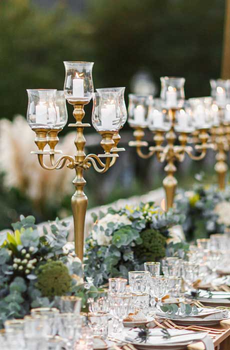A beautiful wedding centerpiece with candlestick holders. 