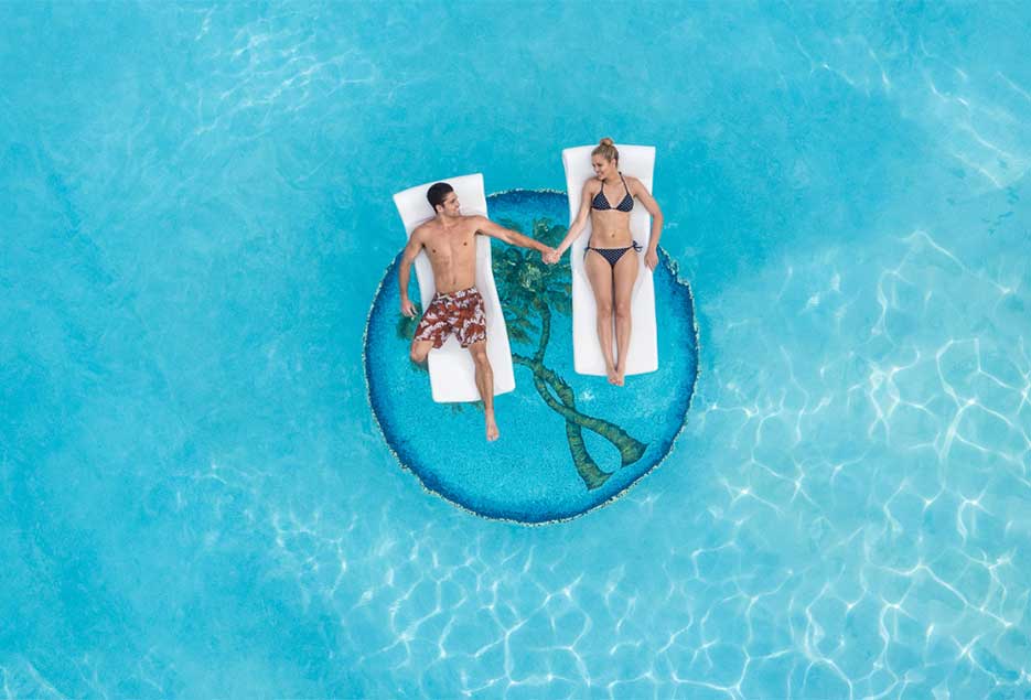 Couple on float in pool at Couples Resorts.