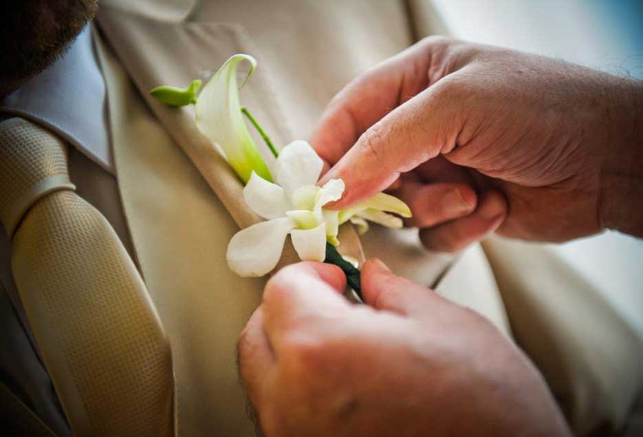 Boutonniere being put on groom 