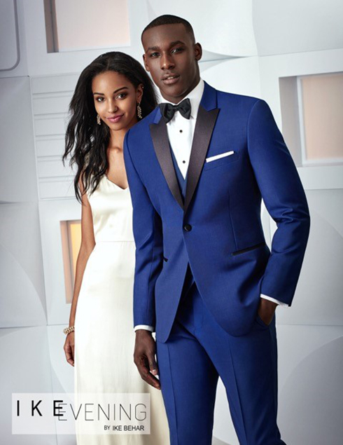 Groom in a Bright Blue Tuxedo with hand in pocket standing next to Bride, Foresto Tuxedo.