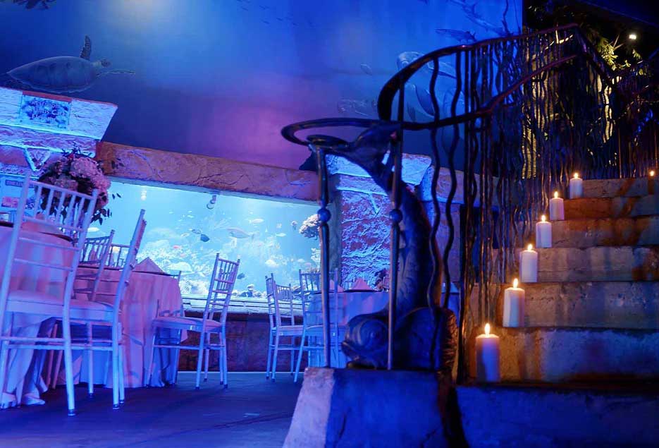A staircase with candles on each step with blue uplighting. 