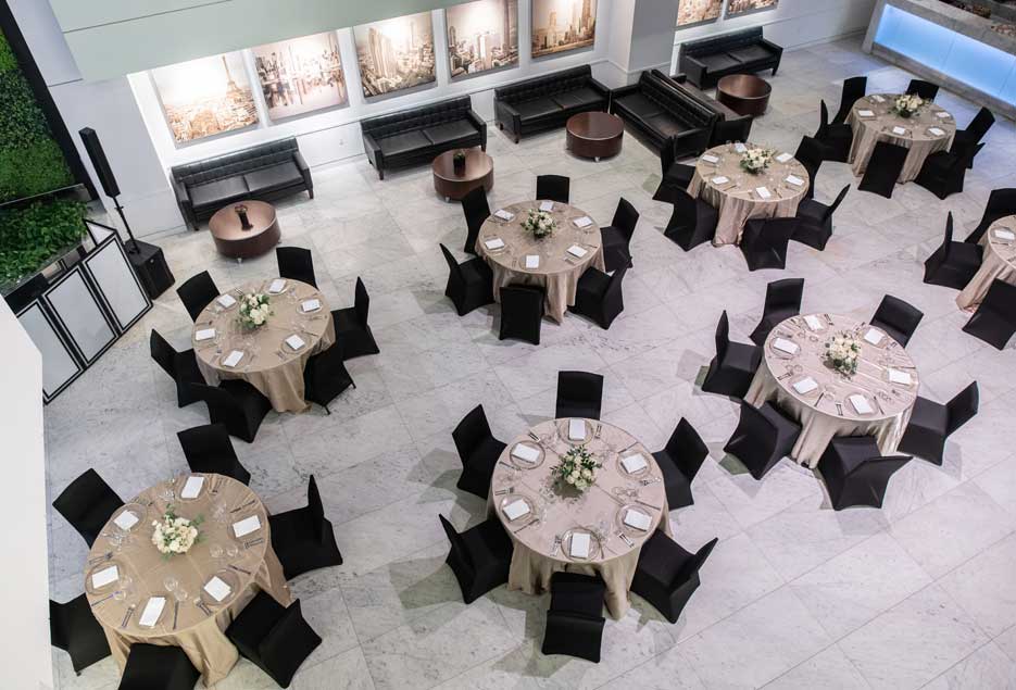 Aerial view of a event table setup with black chair covers. 
