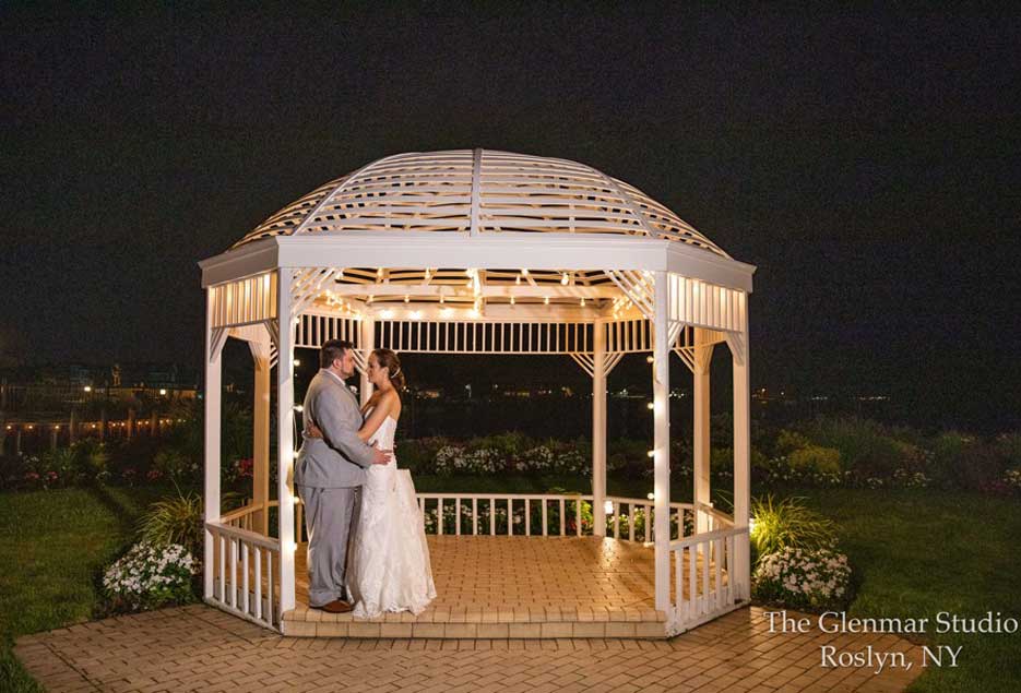 A couple embracing  each other under a gazebo. 