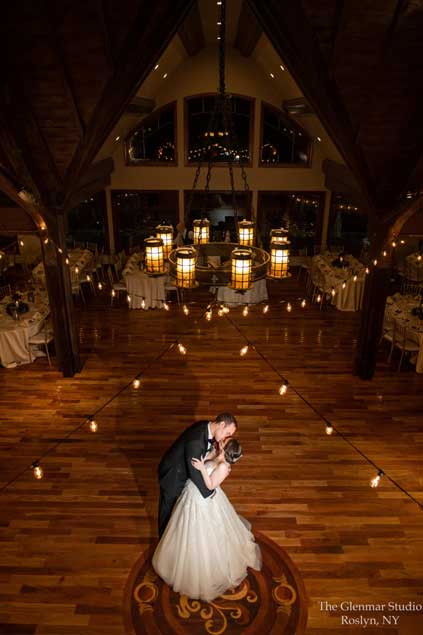 A bride and groom kissing on the dance floor of their wedding reception ballrooom. 