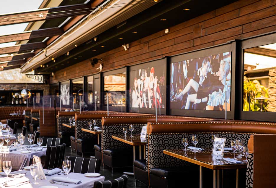 Table and booths at Blackstone with the retractable roof open. 