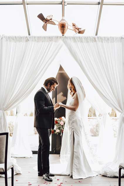 A bride and groom holding hands at One10.