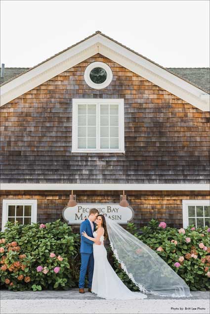 Bride and groom standing in front of the Peconic Bay Yacht Club sign. 
