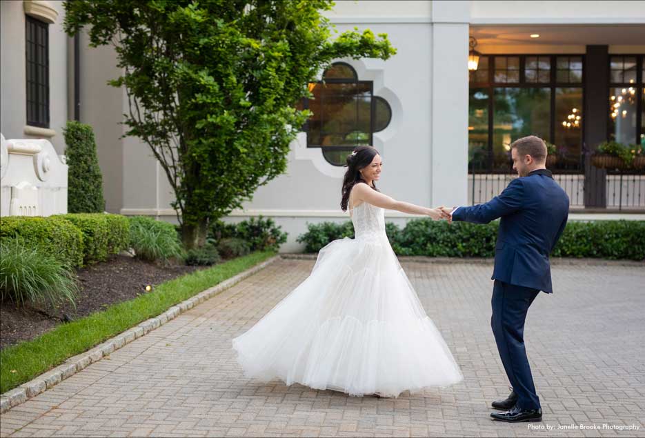 Couple dancing in the outside courtyard of the Village Club at Lake Success. 