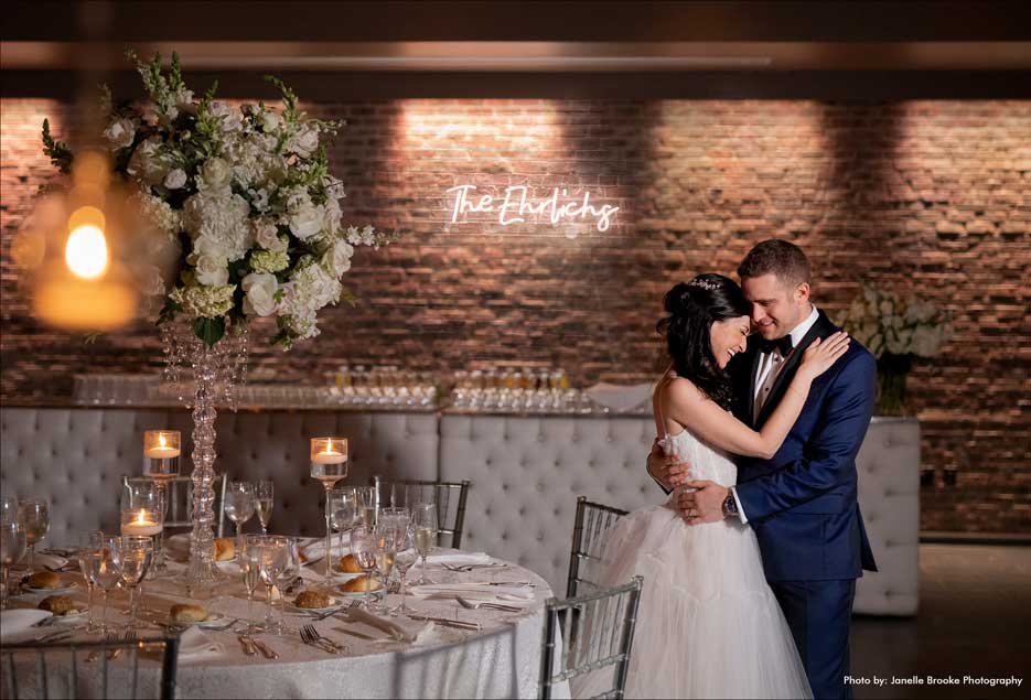 Couple holding each other while in their wedding reception room. 