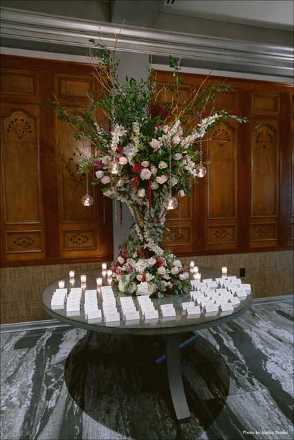 Large flower centerpieces on guest place card table. 