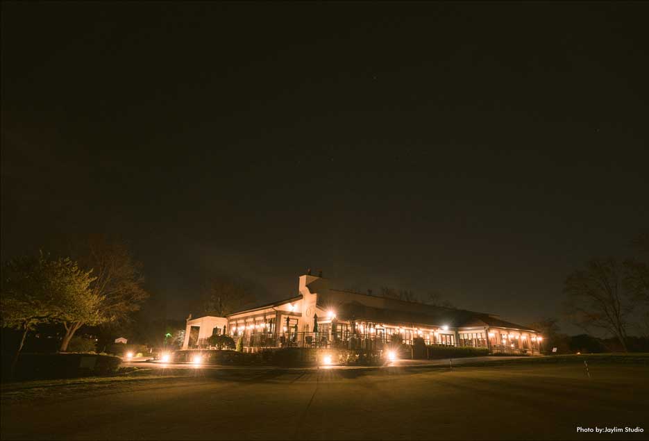 Night time image of the exterior of the Village Club at Lake Success. 