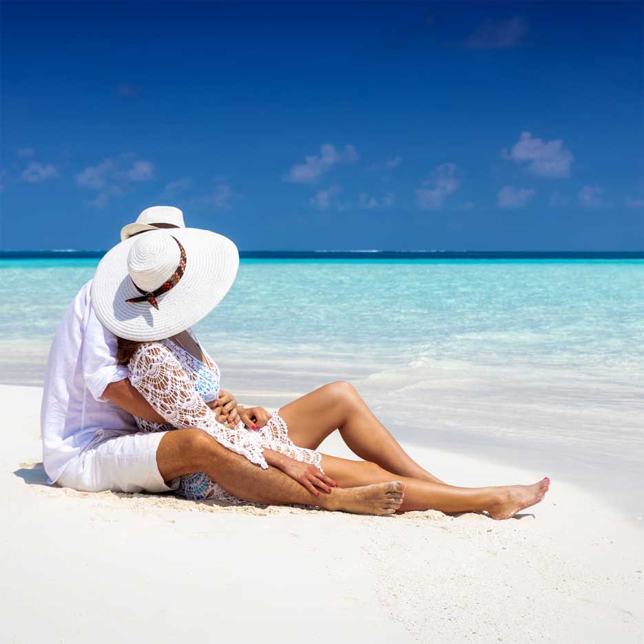 Couple on a sandy beach hugging each other. 